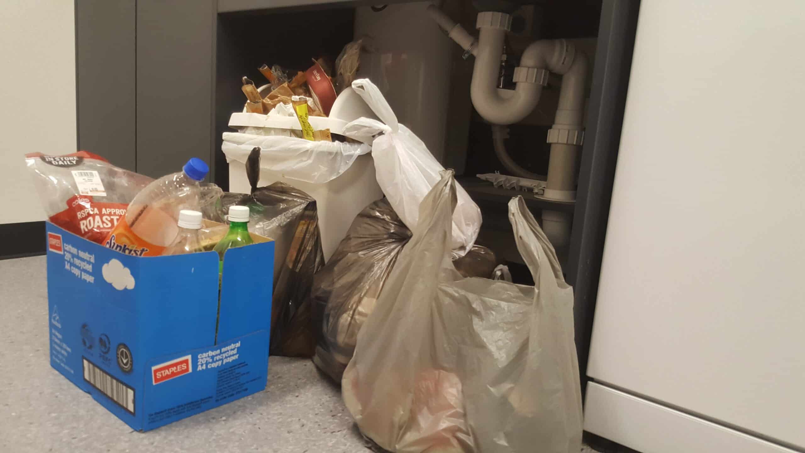 An overflowing humble office bin with extra waste