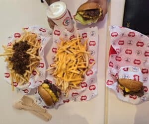 three burgers, cheesy fries and chili fries and a shake at lonely hearts burgers when eating out in Brisbane