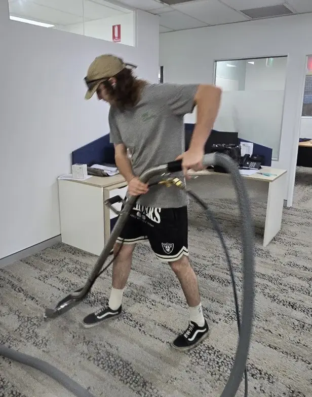 A technician cleaning an office carpet with an office carpet steam cleaning machine