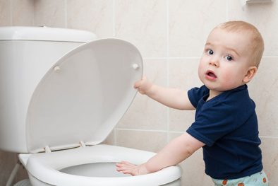 baby holding the toilet bowl