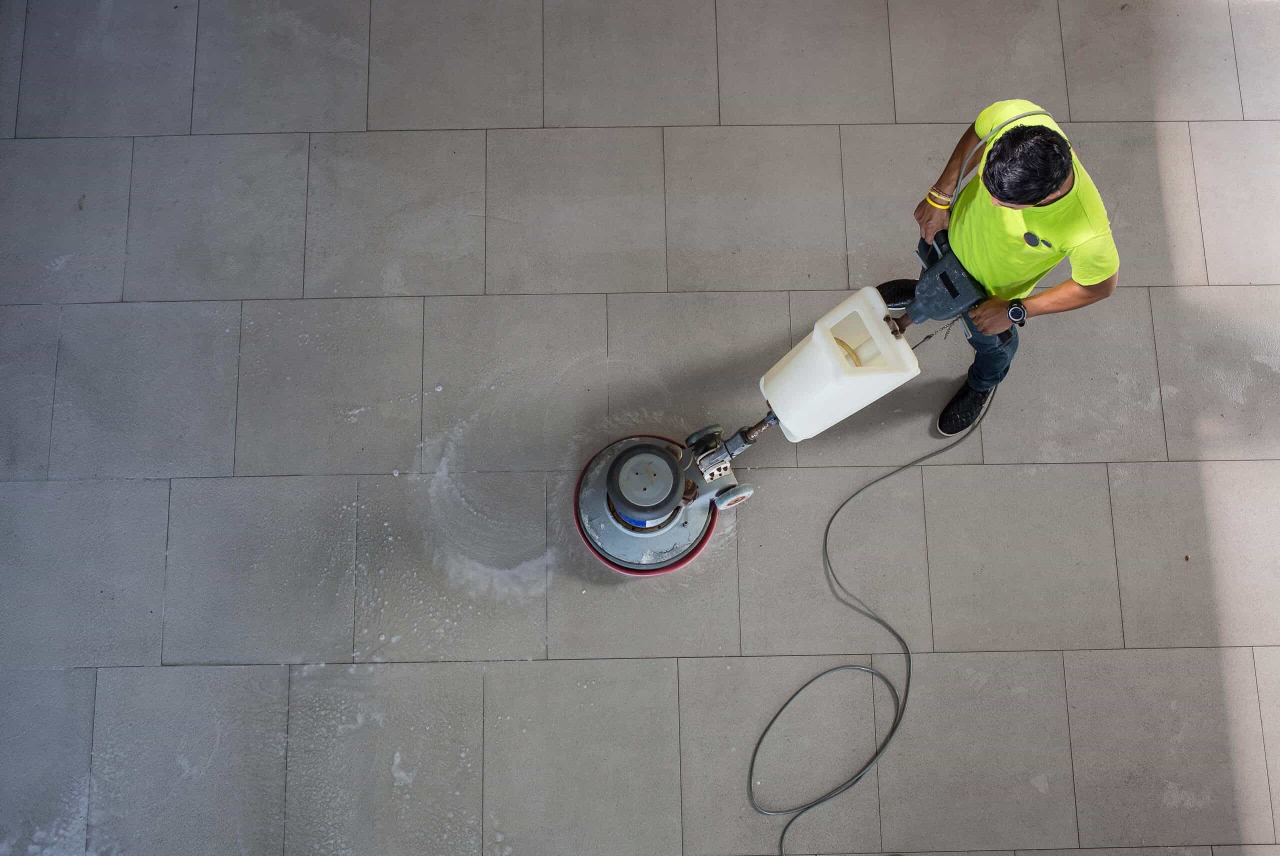 A man cleaning the floor using a cleaning machine