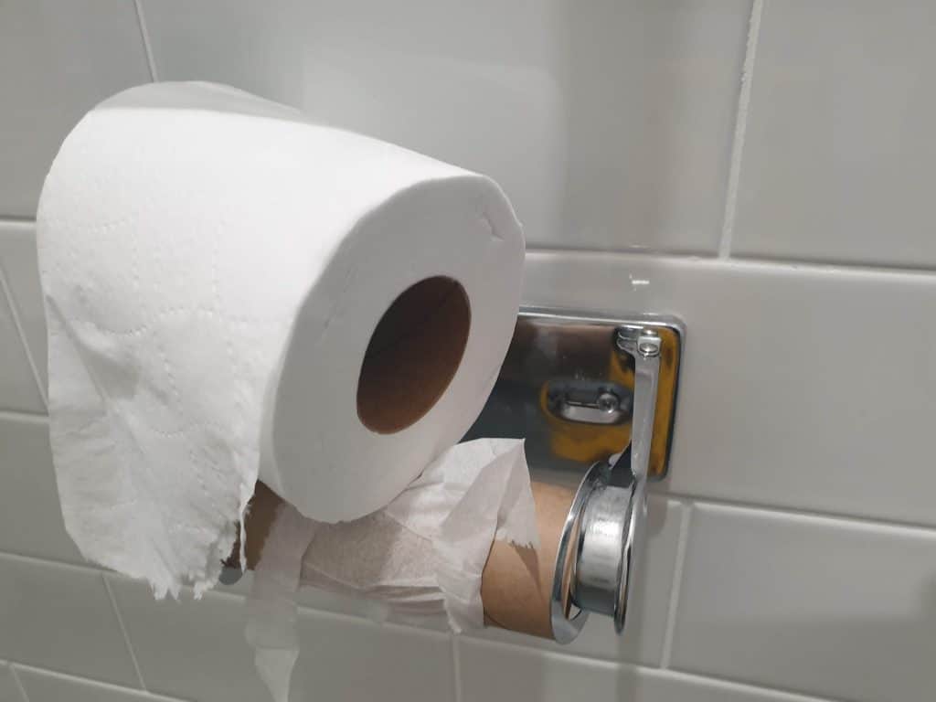 tissue paper roll run out with the full role carelessly placed on top